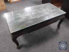An oriental lacquered glass top coffee table depicting dragons