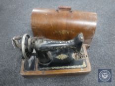 A Singer hand sewing machine in oak case
