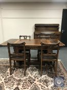 An early 20th century carved oak drawer leaf table and four chairs,