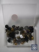 A box containing military and service buttons and badges, miner's lamp token,