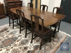 An early 20th century oak pull-out table and six chairs,