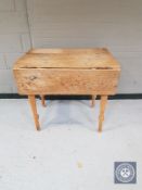 An antique pine drop leaf kitchen table