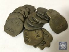 Twenty vintage brass railway pay check tokens.