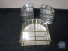 A three-piece brass and glass counter topped display cabinet on bun feet