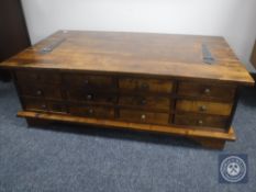 A stained pine storage coffee table fitted with twelve drawers