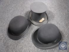A top hat together with two bowler hats by Dunn and Company and Lombard of London