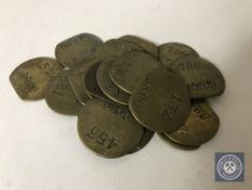 Twenty vintage brass railway pay check tokens.