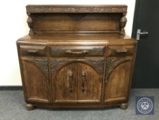 An early 20th century carved oak sideboard,