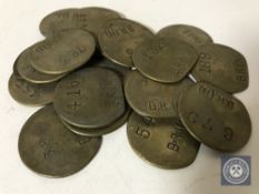 Twenty vintage brass railway pay check tokens.