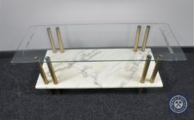 A rectangular glass topped coffee table on a marble effect base