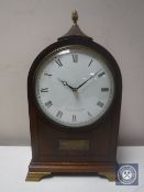 A 20th century inlaid mahogany mantel clock with lion mask handles by Comitti of London on brass