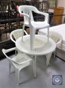 A circular plastic patio table and four chairs