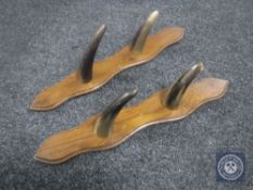 A pair of horn gun racks mounted on a board