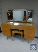 A mid 20th century teak knee hole dressing table and stool