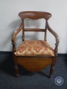 An antique mahogany scroll arm commode chair