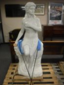 A contemporary carved solid white marble statue of a semi-nude female seated on a rock holding a