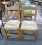 A pair of pine rush seated ladder back kitchen chairs
