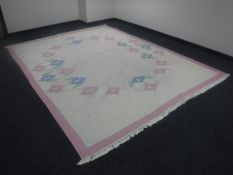A fringed woolen carpet on pink ground