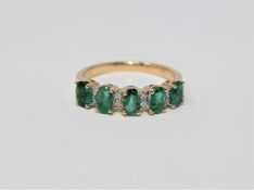 A 14ct yellow gold emerald and diamond ring featuring 5 oval cut natural diamonds 1.