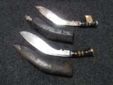 Two kukri knives in leather sheaths