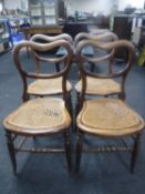 A set of four rosewood bergere seated dining chairs