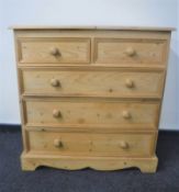 A stripped pine five drawer chest