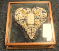 A Victorian beadwork cushion in glazed pine display case