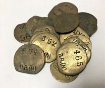Twenty vintage brass railway pay check tokens.