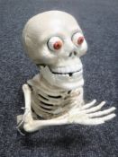 A cast metal skeleton money box