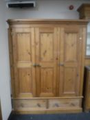 A pine triple door wardrobe fitted two drawers