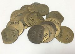 Twenty vintage brass railway pay check tokens.