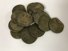 Twenty vintage brass railway pay check tokens.