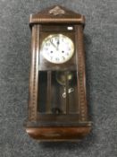 An early 20th century oak cased wall clock with silvered dial