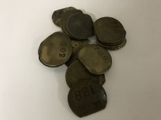 Twenty vintage brass railway pay check tokens.