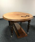A circular Victorian wind out dining table with three leaves