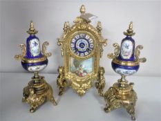 A three piece continental gilt and ceramic clock garniture with enamelled dial and pendulum