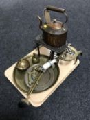 A tray of trivets, antique copper kettle, brass trays,
