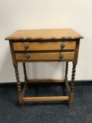 An oak pie crust edge two drawer side table