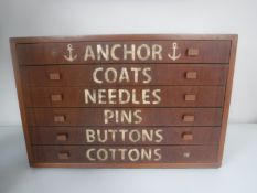 A mid 20th century teak six drawer counter topped chest containing buttons and sewing items