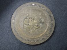 An embossed brass wall plaque depicting a tavern scene