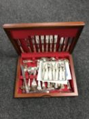 A teak canteen containing a plated cutlery set together with a set of six cake forks