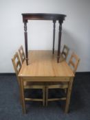 An Ikea pine dining table with four chairs and a D-shaped hall table