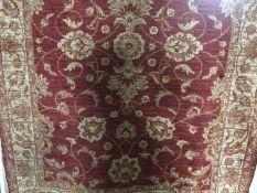 A fringed Ziegler design rug on red ground