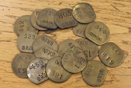 Twenty vintage brass railway pay check tokens.