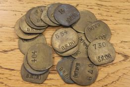 Twenty vintage brass railway pay check tokens.