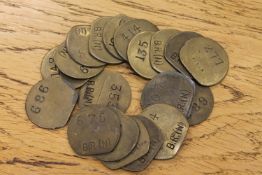 Twenty vintage brass railway pay check tokens.