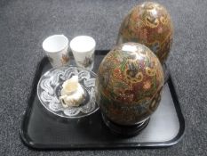 A pair of Chinese eggs on wooden stands,