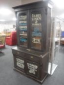 A Victorian glazed door bookcase bearing haberdasher's sign writing