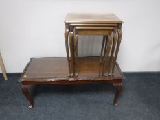 A nest of three walnut tables and a glass topped coffee table