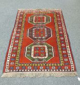 A Caucasian design rug on red ground,